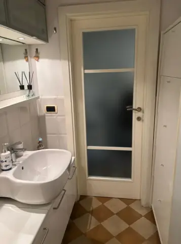 Il lavabo del bagno e il pavimento a scacchi in cotto